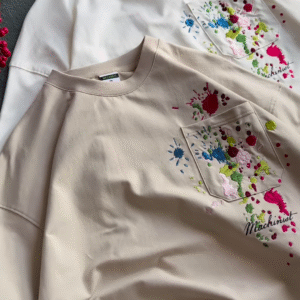 Unisex White & Beige T-Shirts with Colorful Paint Splatter and Pocket Embroidery – Artistic Casualwear for Everyday Styling